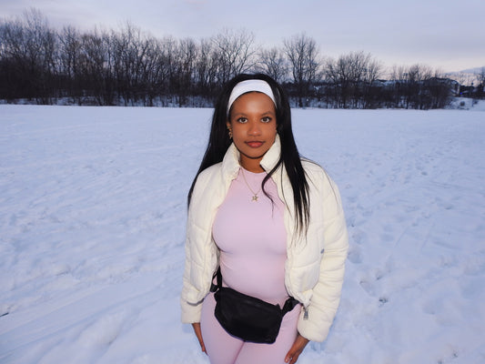 College age girl in the snow wearing 18k gold plated star necklace and a light pink workout set